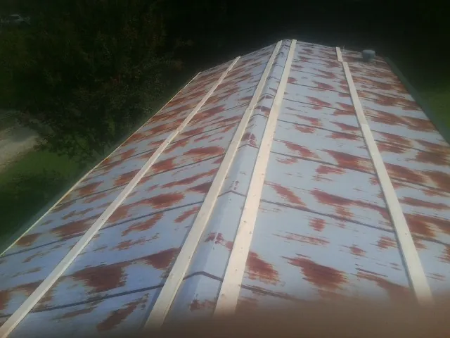 Rusted metal roof panels with new wood purlins before replacement — Storm Damage Roof Repair in Sand Creek by Roofing Brothers