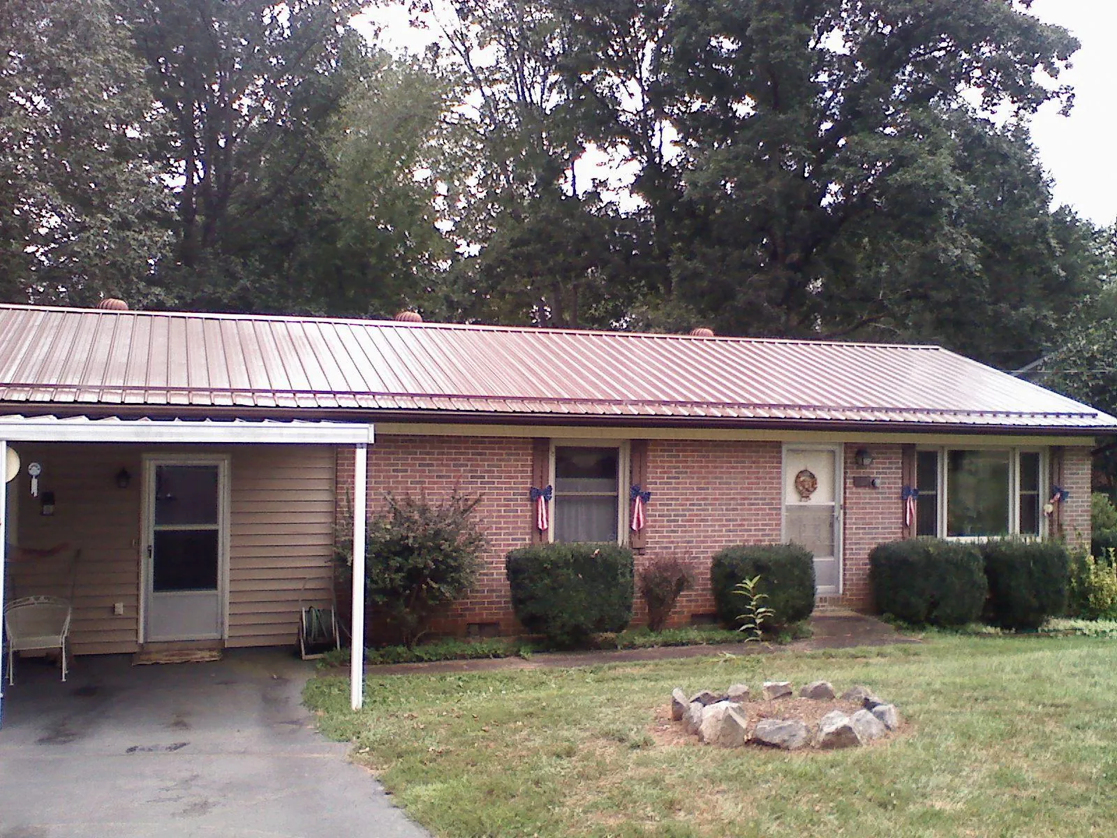 Bronze metal roof and carport on a brick ranch home — Roof Repair work by our crew in Sand Creek